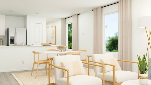 dining space featuring baseboards and light wood finished floors