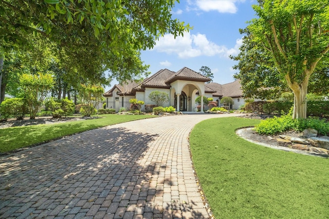 25 Kings Lake Estates Blvd, Humble, TX 77346 - mediterranean / spanish house featuring fence, a tile roof, stucco siding, a front yard, and curved driveway