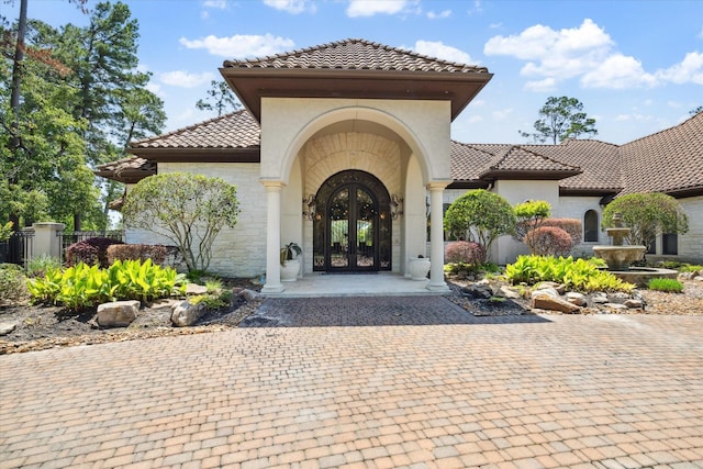25 Kings Lake Estates Blvd, Humble, TX 77346 - doorway to property featuring a tiled roof, stucco siding, french doors, and stone siding