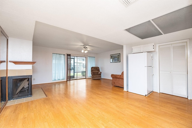 14777 Wunderlich Dr Unit 1103, Houston, TX 77069 - unfurnished living room with visible vents, a fireplace, baseboards, ceiling fan, and light wood finished floors