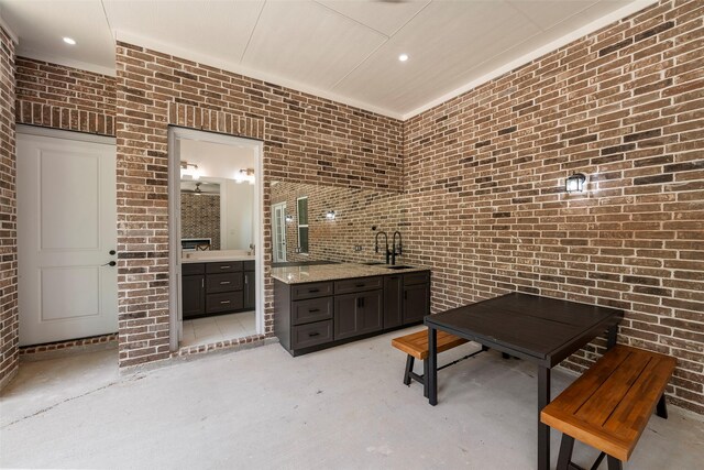 58-D Hickory Ridge Dr, Huffman, TX 77336 - bathroom featuring brick wall, concrete flooring, two vanities, a sink, and recessed lighting