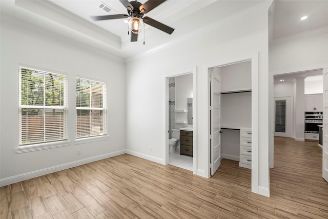 58-D Hickory Ridge Dr, Huffman, TX 77336 - unfurnished bedroom featuring visible vents, ornamental molding, light wood-style flooring, and a spacious closet