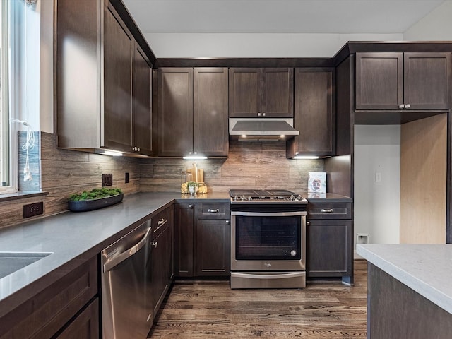 302 Eado Park Cir, Houston, TX 77020 - kitchen featuring decorative backsplash, dark wood-style flooring, dark brown cabinetry, under cabinet range hood, and appliances with stainless steel finishes