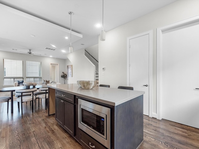 302 Eado Park Cir, Houston, TX 77020 - kitchen with dark wood-style flooring, dark brown cabinets, stainless steel microwave, visible vents, and pendant lighting