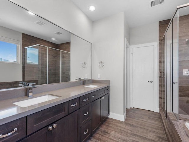 302 Eado Park Cir, Houston, TX 77020 - full bathroom featuring a sink, a shower stall, wood finished floors, and visible vents