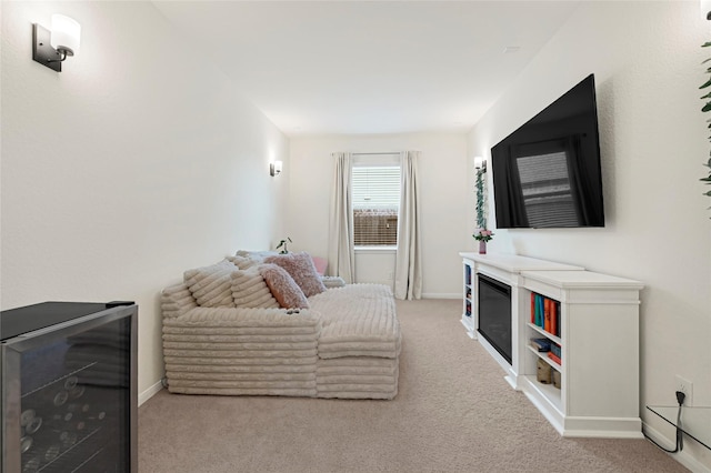 living room featuring baseboards, light colored carpet, and wine cooler
