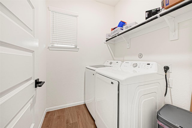 washroom featuring laundry area, light wood-style flooring, baseboards, and washer and dryer