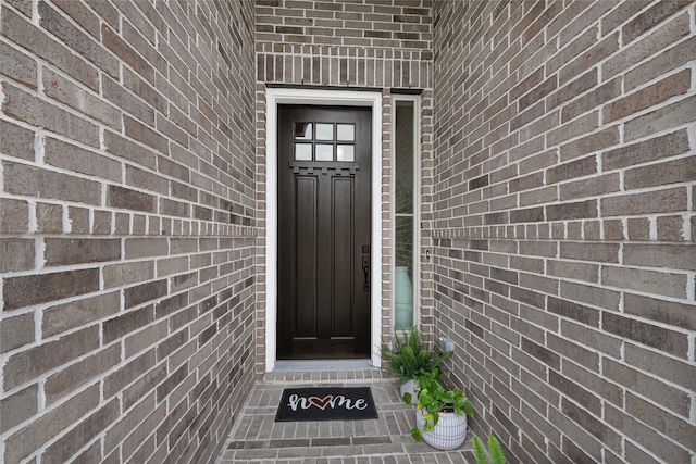property entrance featuring brick siding