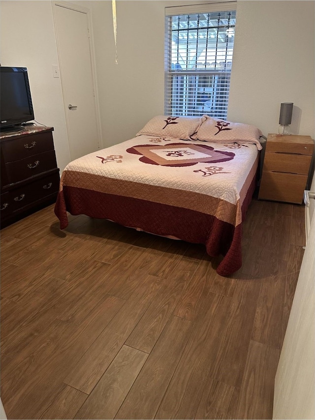 bedroom with dark wood-style floors