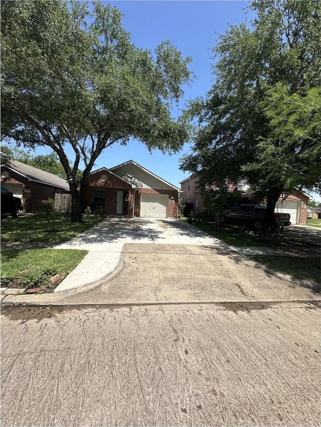 single story home with concrete driveway and an attached garage