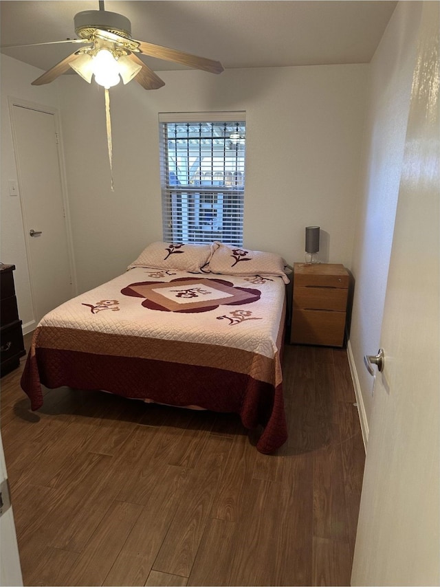 bedroom with a ceiling fan and dark wood-type flooring
