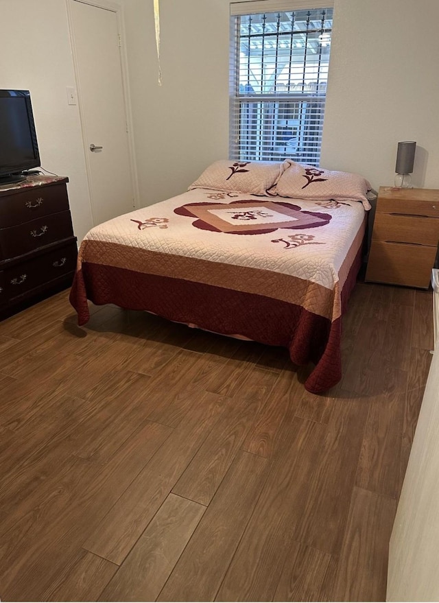 bedroom with dark wood finished floors