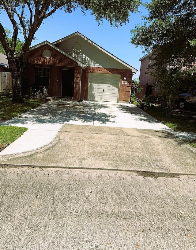 view of front of property with brick siding, driveway, and a garage