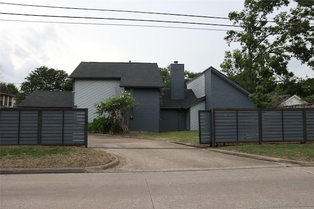 1035 Wirt Rd, Houston, TX 77055 - view of property exterior featuring brick siding, aphalt driveway, fence, and a chimney
