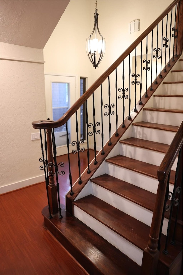 1035 Wirt Rd, Houston, TX 77055 - staircase featuring baseboards, lofted ceiling, wood finished floors, and an inviting chandelier