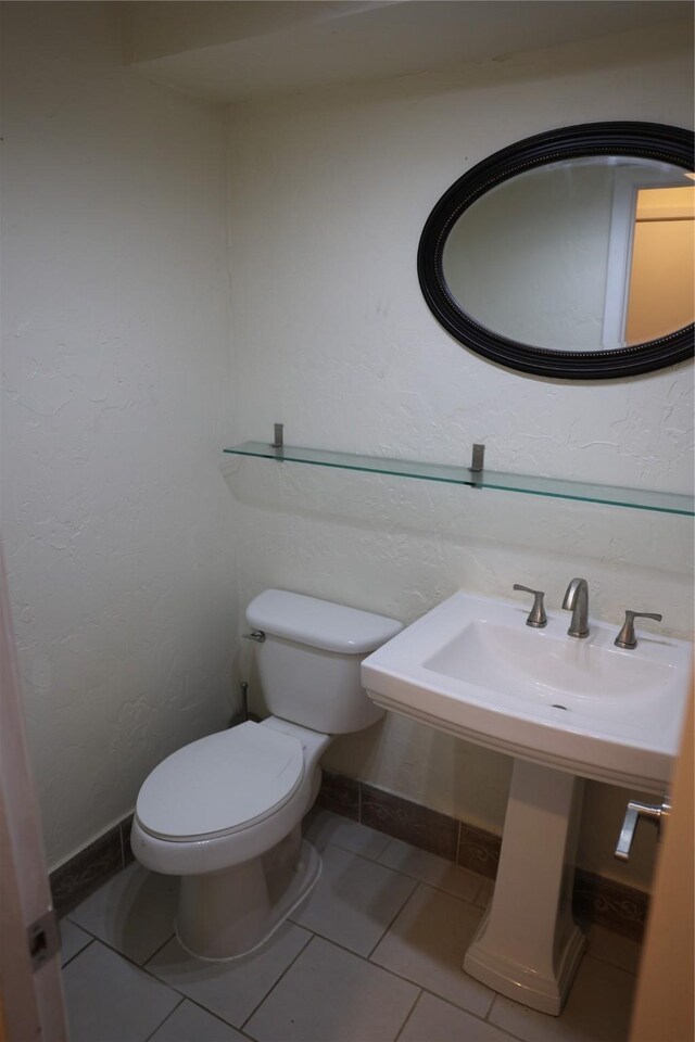 1035 Wirt Rd, Houston, TX 77055 - bathroom featuring baseboards, a textured wall, tile patterned floors, and toilet