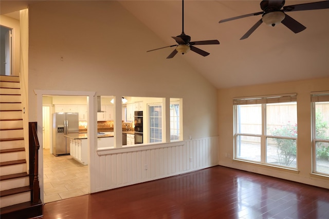 1035 Wirt Rd, Houston, TX 77055 - unfurnished living room featuring a ceiling fan, wood finished floors, high vaulted ceiling, and stairway