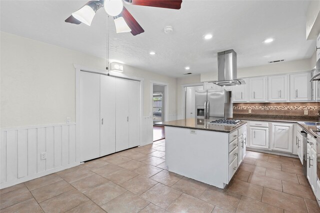 1035 Wirt Rd, Houston, TX 77055 - kitchen featuring appliances with stainless steel finishes, island range hood, dark countertops, backsplash, and a ceiling fan