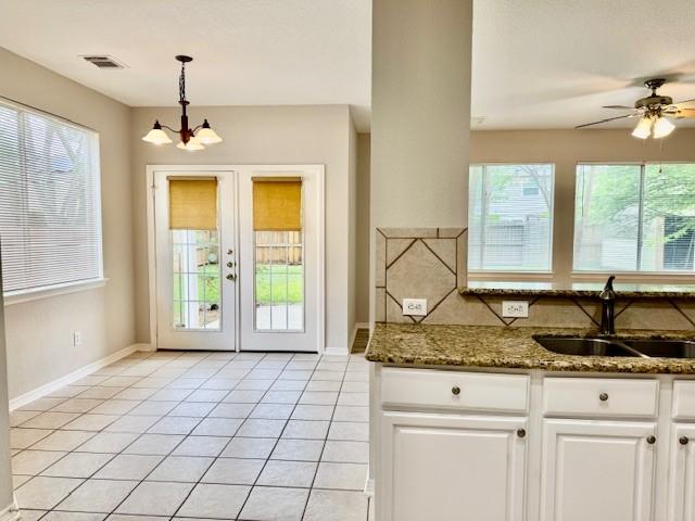 doorway featuring light tile patterned flooring, visible vents, a healthy amount of sunlight, and a sink