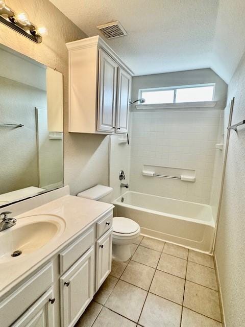 bathroom with a textured wall, vanity, toilet, tile patterned floors, and visible vents