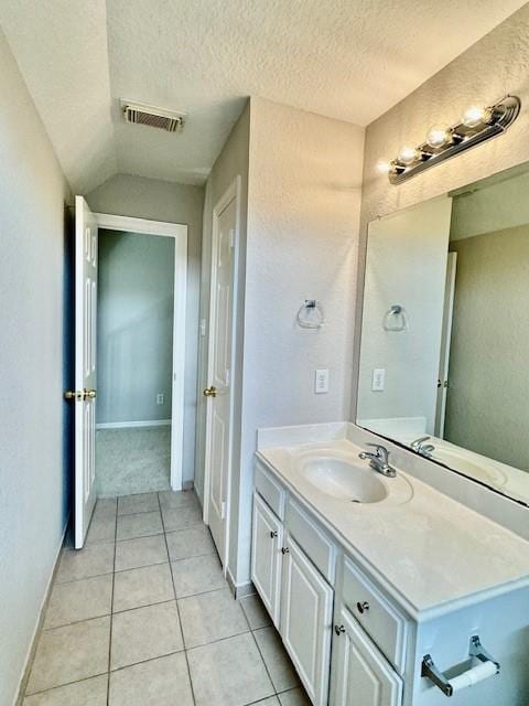 bathroom with visible vents, tile patterned flooring, vanity, baseboards, and a textured ceiling