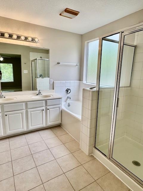 bathroom with a sink, tile patterned floors, and a shower stall
