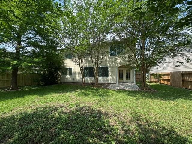 view of yard with french doors, a patio, and a fenced backyard