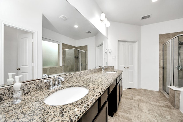 full bathroom with visible vents, a sink, double vanity, and a shower stall