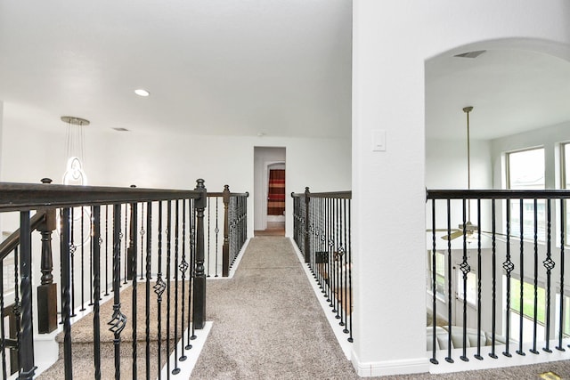 hall featuring arched walkways, baseboards, recessed lighting, and carpet