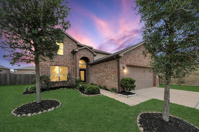 traditional home with driveway, a front yard, brick siding, fence, and an attached garage