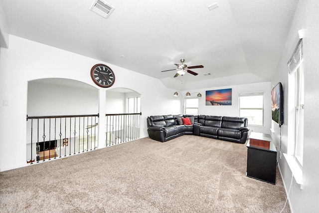 living room featuring carpet floors, ceiling fan, and visible vents