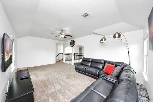 living room with visible vents, carpet floors, lofted ceiling, ceiling fan, and a textured ceiling