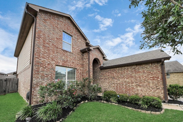 view of front of home with fence, a front yard, and brick siding