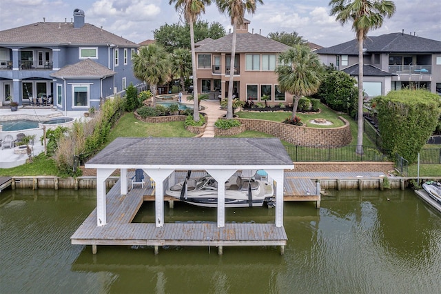 dock area featuring boat lift, a balcony, a fenced backyard, a patio area, and a water view