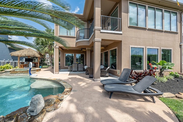 exterior space featuring an outdoor hangout area, a ceiling fan, a pool with connected hot tub, and a patio area