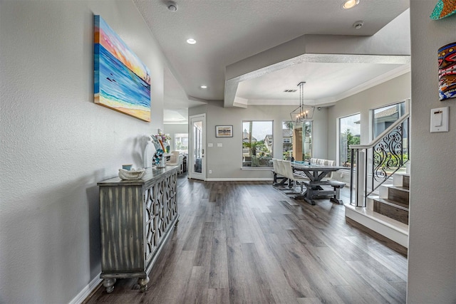 entryway with wood finished floors, stairway, baseboards, an inviting chandelier, and ornamental molding