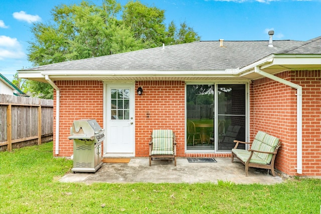 123 S Yaupon St, Lake Jackson, TX 77566 - rear view of house with roof with shingles, fence, brick siding, a patio area, and a lawn