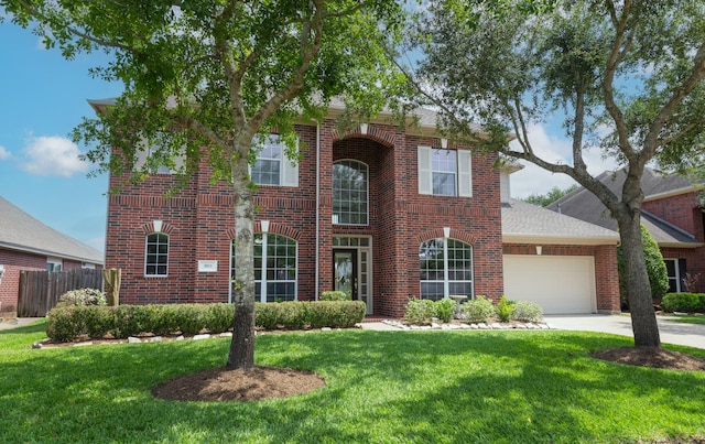 view of front facade featuring fence, brick siding, a garage, a front yard, and concrete driveway