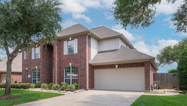 traditional home featuring fence, brick siding, a shingled roof, concrete driveway, and an attached garage