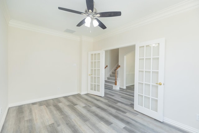empty room with crown molding, a ceiling fan, baseboards, and wood finished floors