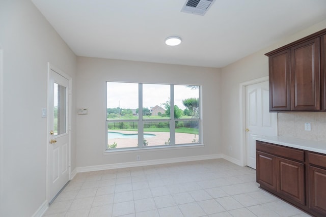 kitchen with light countertops, baseboards, light tile patterned floors, and visible vents