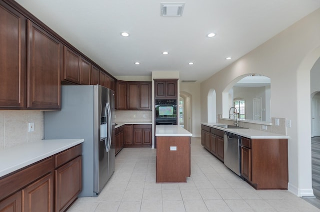 kitchen featuring visible vents, recessed lighting, arched walkways, a sink, and appliances with stainless steel finishes