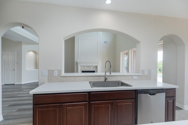 kitchen featuring a sink, light countertops, baseboards, and dishwasher