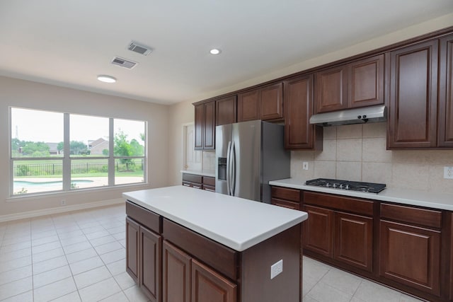 kitchen with light tile patterned floors, appliances with stainless steel finishes, under cabinet range hood, and visible vents