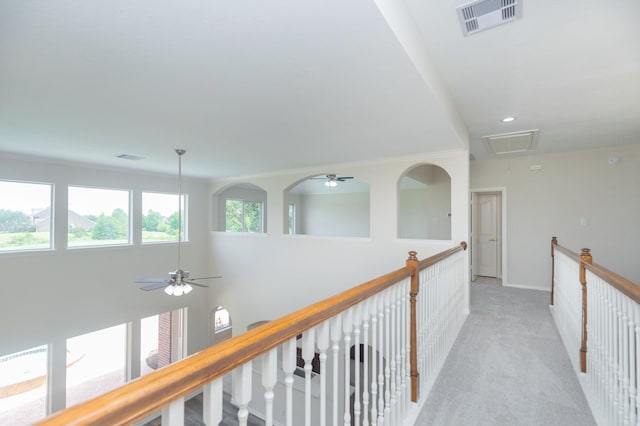 hall with visible vents, attic access, baseboards, and light carpet