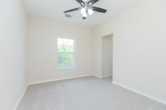 unfurnished room featuring baseboards, visible vents, ceiling fan, and carpet