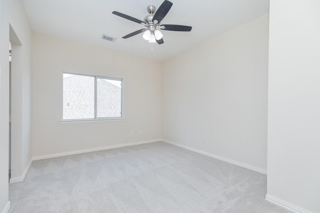 empty room with visible vents, baseboards, ceiling fan, and light carpet