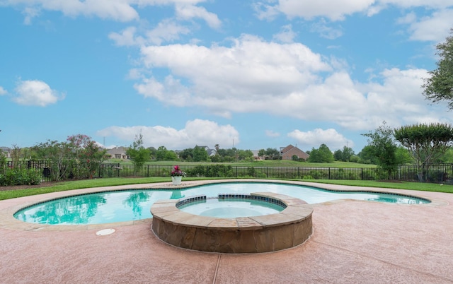 view of pool with a fenced backyard, a pool with connected hot tub, and a patio area