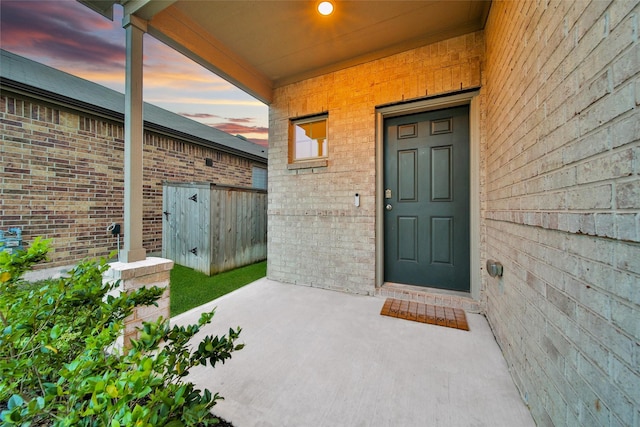 exterior entry at dusk with brick siding