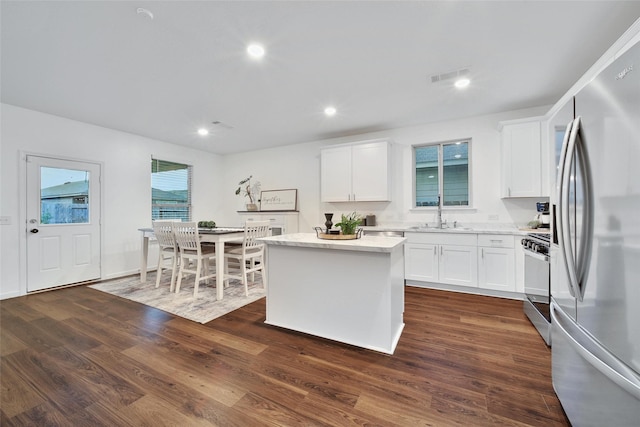 16322 Fontana Ct, Conroe, TX 77302 - kitchen with appliances with stainless steel finishes, a center island, white cabinets, dark wood-style flooring, and recessed lighting